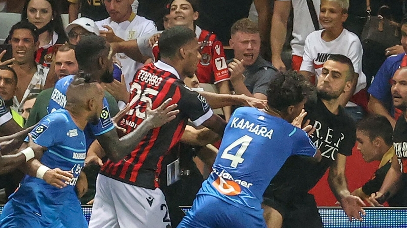 Marseille's Dimitri Payet (L) reacts as players stop a fan (R) invading the pitch