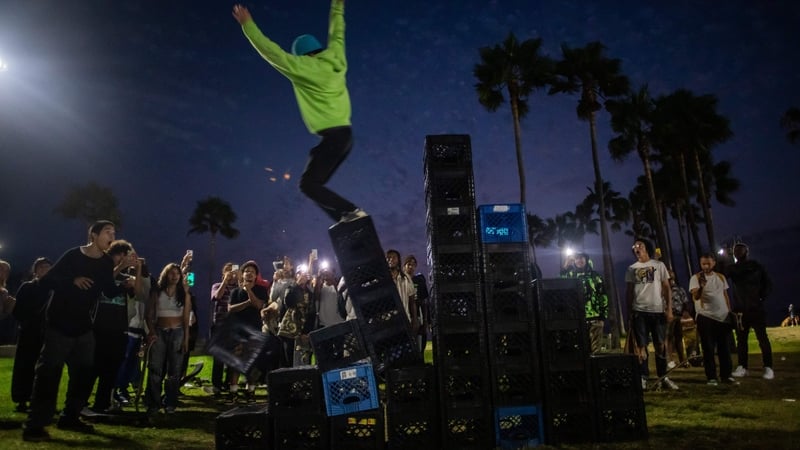 A man falls down a pyramid of milk crates while participating in the Milk Crate Challenge in Venice, California