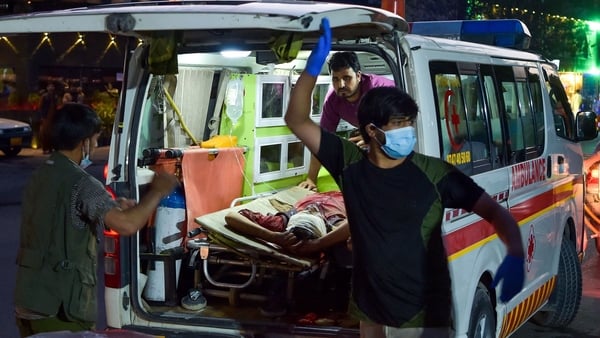 Medical staff bring an injured man to a hospital after two explosions killed several people in Kabul