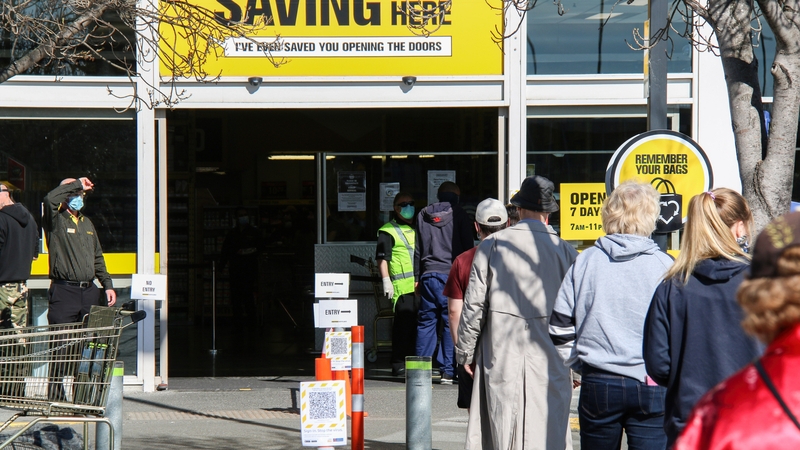 People queue to enter a supermarket in Christchurch, New Zealand