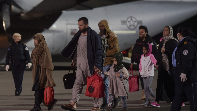 Afghan refugees, fleeing Kabul, exit an US air force plane upon their arrival at Pristina International airport in Kosovo