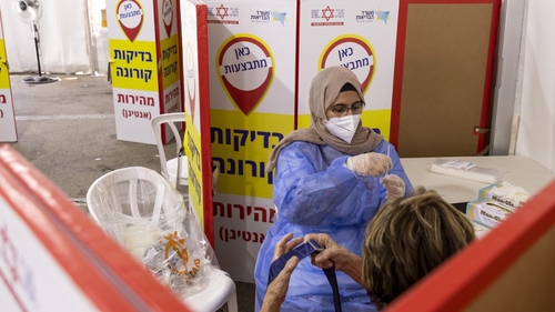 A health worker prepares a swab sample for Covid-19 rapid antigen tests at the Magen David Adom drive-through testing facility in Tel Aviv