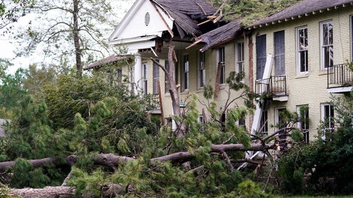 A home is severely damaged by trees downed by the storm in Covington, Louisiana