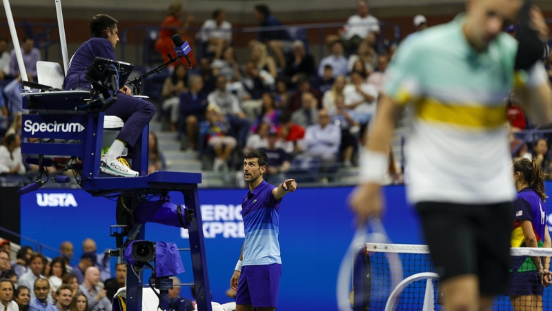Novak Djokovic points to a rambunctious spectator in the Arthur Ashe Stadium crowd intent on distracting the world number one