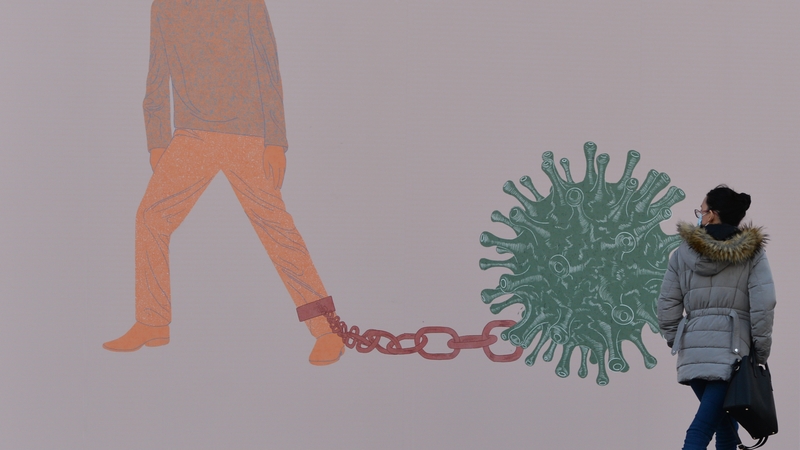 A woman walks past a Covid-19 related display at the Science Gallery in Dublin