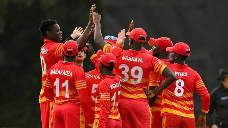 Blessing Muzarabani is mobbed by team-mates after claiming the wicket of Ireland's George Dockrell