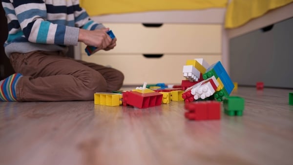 A child playing with toy bricks in a creche