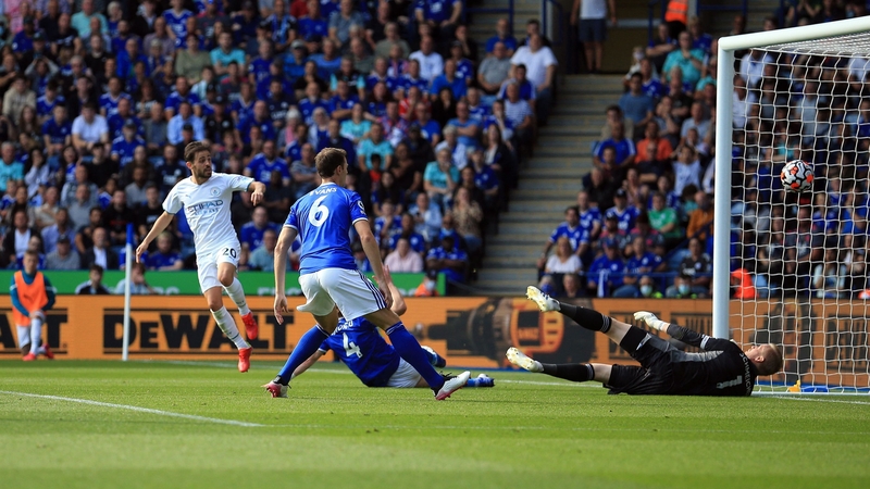 Bernardo Silva (L) scores past Leicester City goalkeeper Kasper Schmeichel (R)