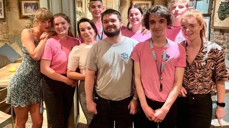 Taylor Swift (left) with the staff of the Tipsy Bird in Belfast