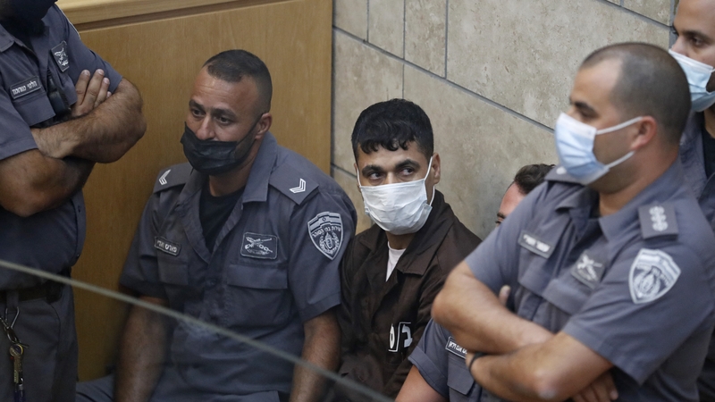 Mahmud Abdullah Ardah, one of the six prisoners who escaped from a high-security prison earlier this week, is surrounded by Israeli police officers during his trial at the magistrates' court in the northern Israeli city of Nazareth