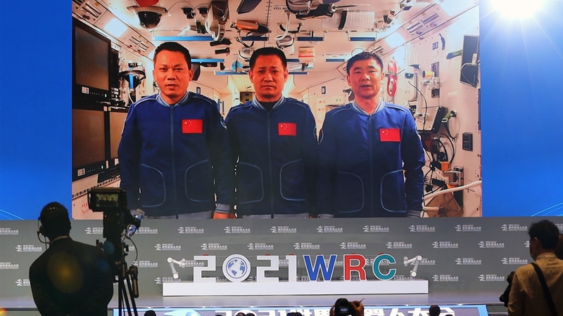 A screen shows Nie Haisheng, Liu Boming and Tang Hongbo speaking on board the Tiangong space station on 10 September