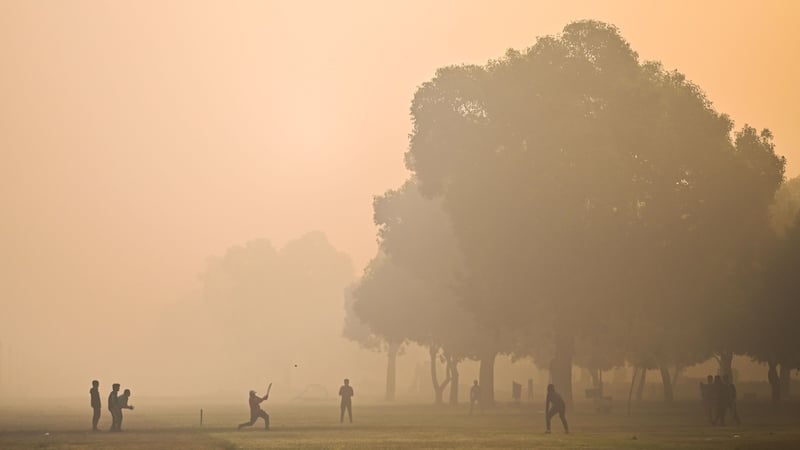 People play cricket at a park amid smoggy conditions in New Delhi, India