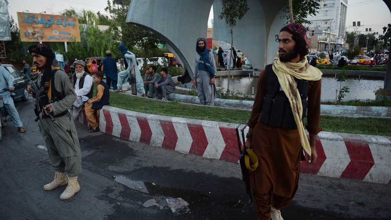 Taliban fighters stand guard along a road in Herat (File pic)