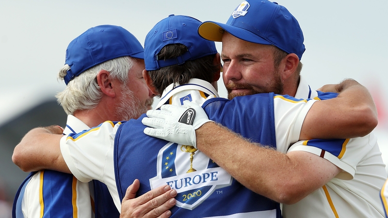 Shane Lowry (R) embraces Bo Martin and Harry Diamond