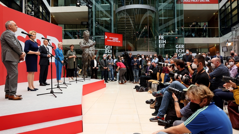 Olaf Scholz (centre on stage) gives a media briefing along with party colleagues in Berlin today