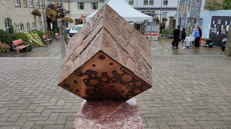 The sculpture is titled 'Meitheal'