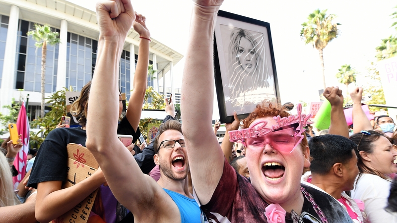 A Britney Spears fan that goes by the name Jakeyonce, right, celebrates outside the courtroom after singer's legal victory