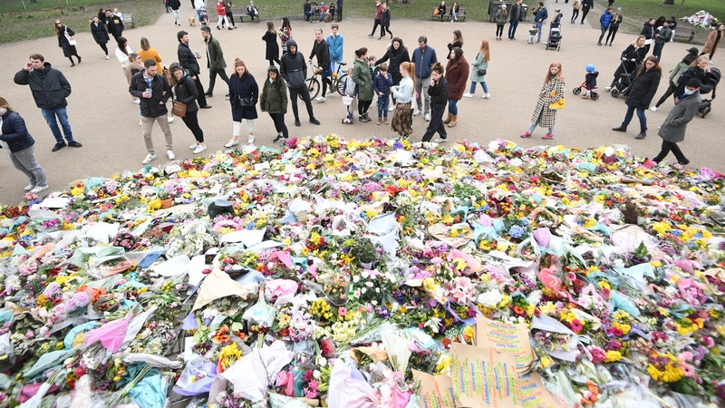 People view floral tributes left in March at the bandstand in Clapham Common, London for Sarah Everard