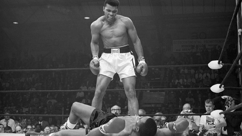 Muhammad Ali stands over Sonny Liston in their second world title fight in 1965
