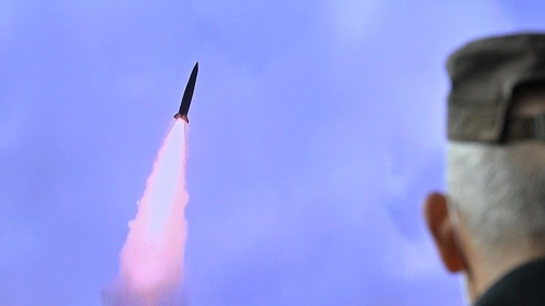 A man watches a television report showing a news broadcast with file footage of a North Korean missile test (File image)