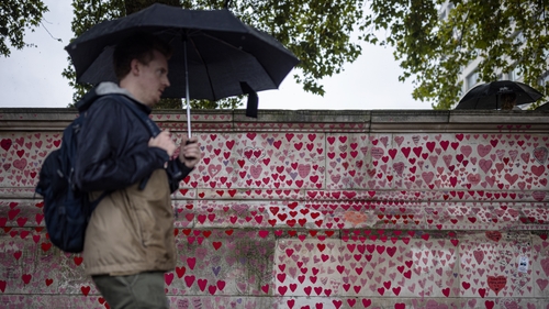 A man is seen walking by the National Covid Memorial Wall in London