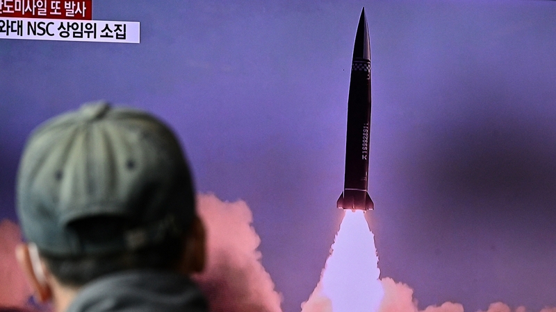 A man watches a news broadcast with file footage of a North Korean missile test