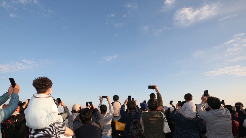 People watch the launch from an observation deck