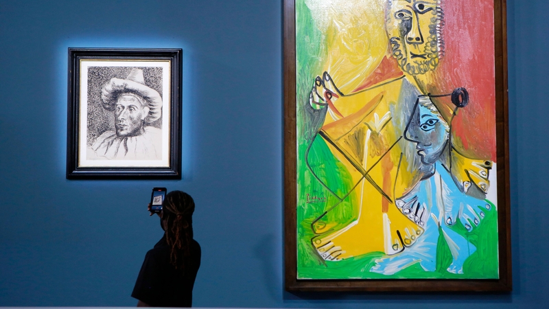 A guest takes a photograph of Picasso's "Pierrot," (L) near "Homme et enfant"