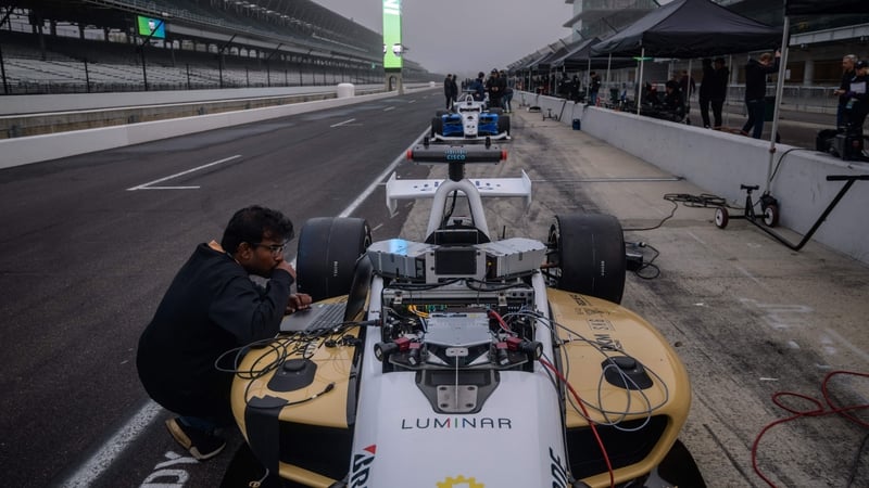 Team members of Black & Gold Autonomous Racing check their car prior to the Indy Autonomous Challenge race at the Indianapolis Speedway