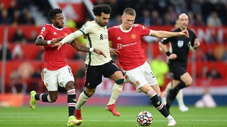 Mohamed Salah of Liverpool holds off Fred and Scott McTominay