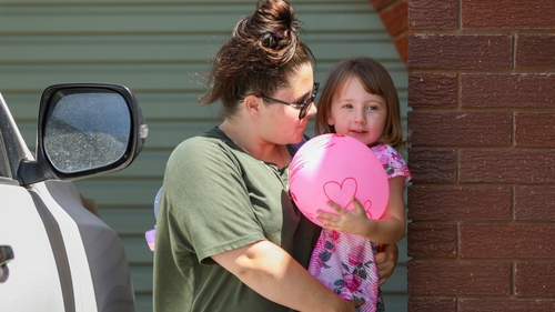 Cleo Smith being carried inside a friend's house by her mother