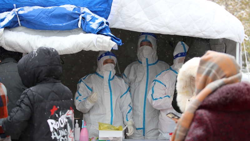Medical workers take swab samples on residents in a mass Covid-19 test in the snow in northwest China