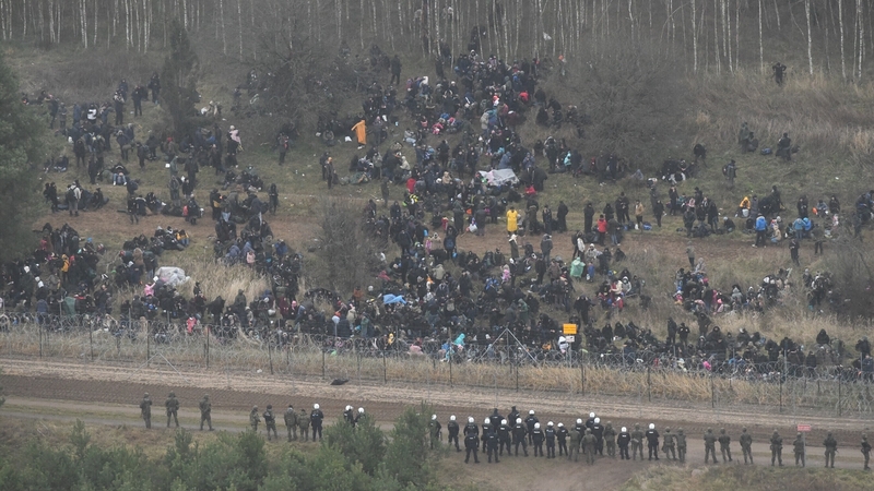 Border army units stand guard as migrants gather near the Kuznica border crossing on the Belarusian-Polish border in Kuznica, Poland