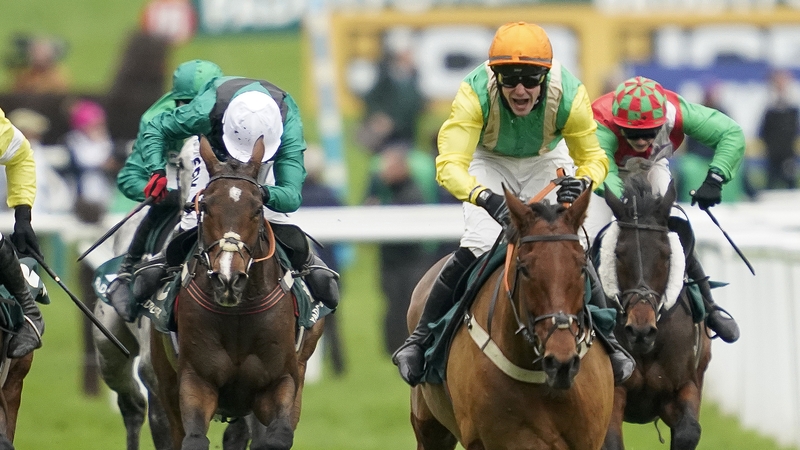 Ryan Mania celebrates as Midnight Shadow (orange cap) crosses the line