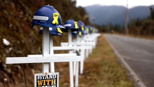 29 white crosses and helmets are pictured on the access road to the Pike River Mine