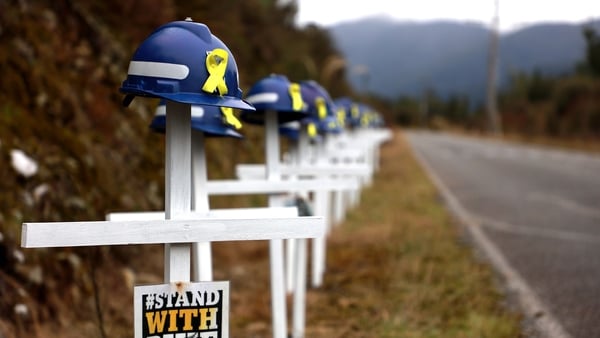 29 white crosses and helmets are pictured on the access road to the Pike River Mine