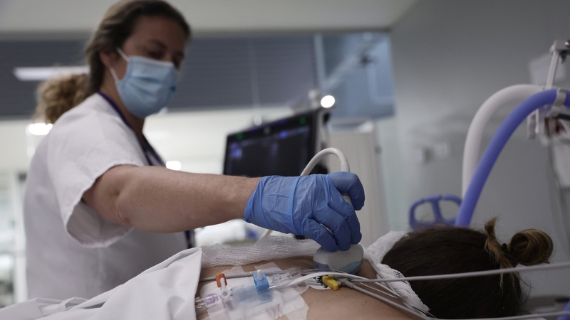 A nurse performs an ultrasound scan on a patient in the ICU of the Hospital Enfermera Isabel Zendal in Madrid
