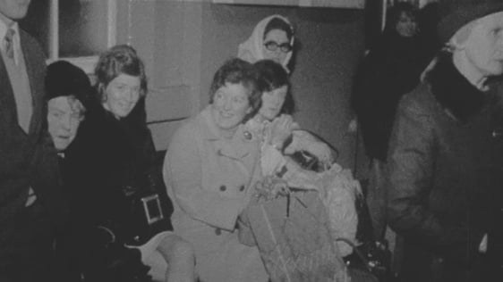 Emigrants home for Christmas holidays waiting in train station (1971)