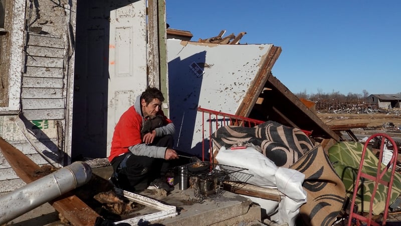 James Strickland sits on the porch of his father's home which was destroyed when a tornado ripped through his town