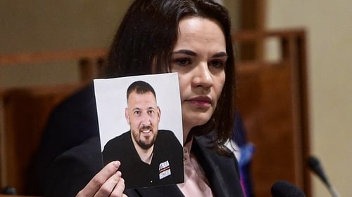 Belarus opposition leader Svetlana Tikhanovskaya holding a picture of her husband who was detained in August 2020