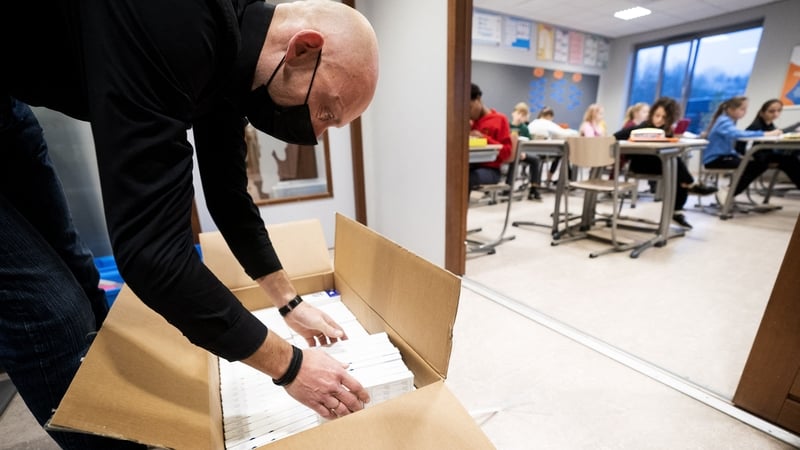 A man unpacks boxes of corona self-tests at primary school De Horizon in Harmelen