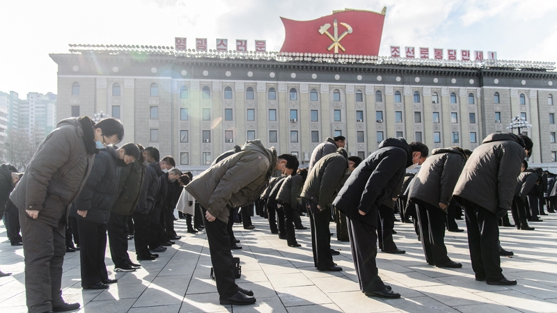 People bow during a three minutes silence to mark the ten year anniversary of the death of Kim Jong Il