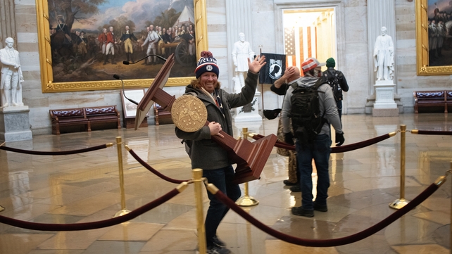 6 January: A pro-Trump protester carries the lectern of US Speaker of the House Nancy Pelosi through the US Capitol Building after a pro-Trump mob stormed the building (Photo: Win McNamee)