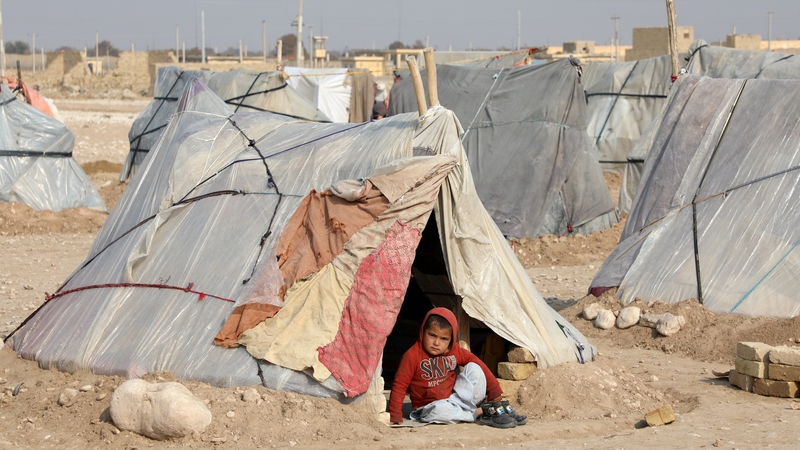 A boy sits at a tent at a refugee camp in Balkh, Afghanistan. A million children face imminent starvation in the country, according to UNICEF