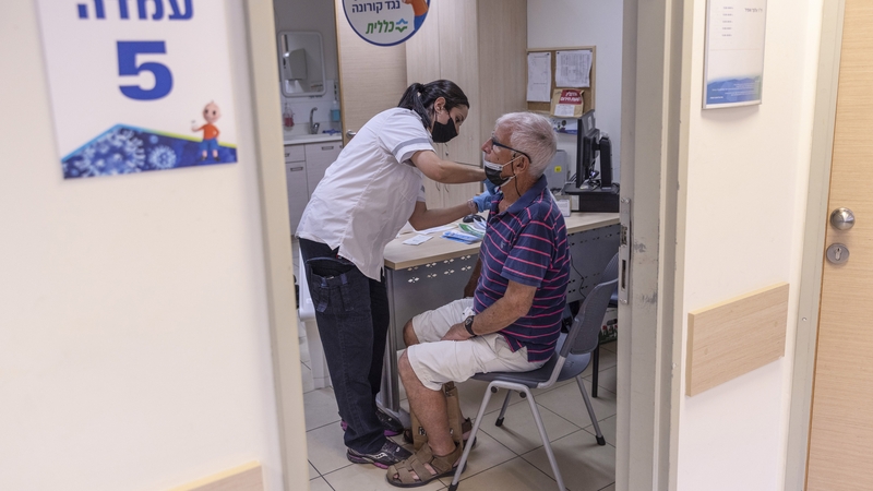 A Tel Aviv resident pictured receiving a third vaccine dose last August