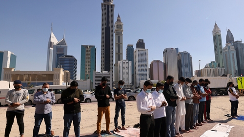 Muslim men perform Friday noon prayer in an area close to their workplace on the first working Friday