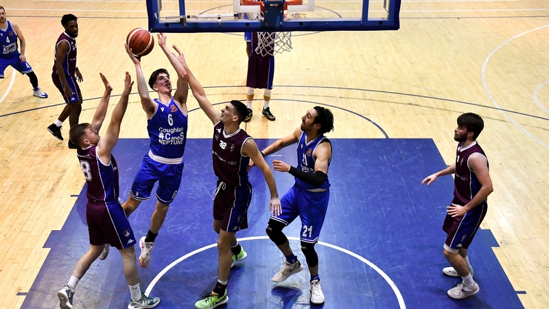 Cian Heaphy of C&S Neptune leaps over Stephen Commins and Luka Kraljic.
