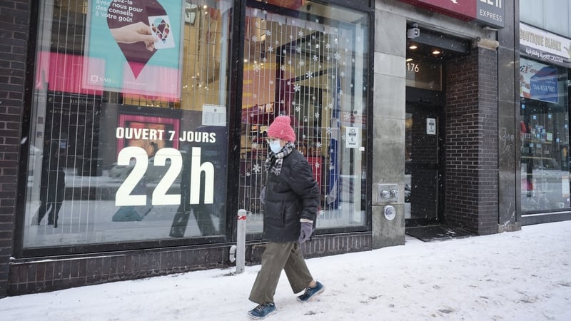 A pedestrian walks past a closed shop in Montreal, Quebec on Sunday. Shops in the province are shut on Sundays for the next few weeks
