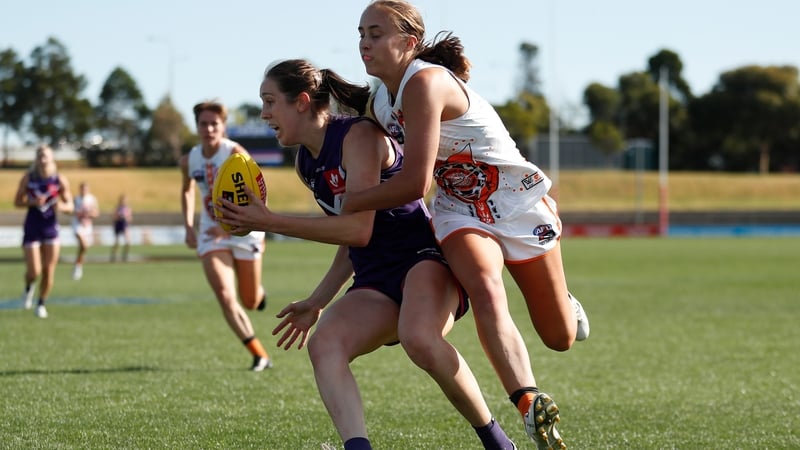 Áine Tighe of the Fremantle Dockers fends off Greater Western Sydney Giants' Georgia Garnett