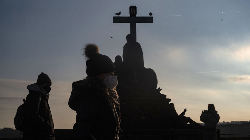 Tourists wearing protective face masks walk across Charles Bridge in Prague earlier this wek